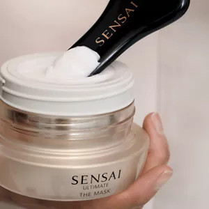 Nahaufnahme einer Person, die mit dem Spatel Ultimate The Mask aus dem Tiegel entnimmt